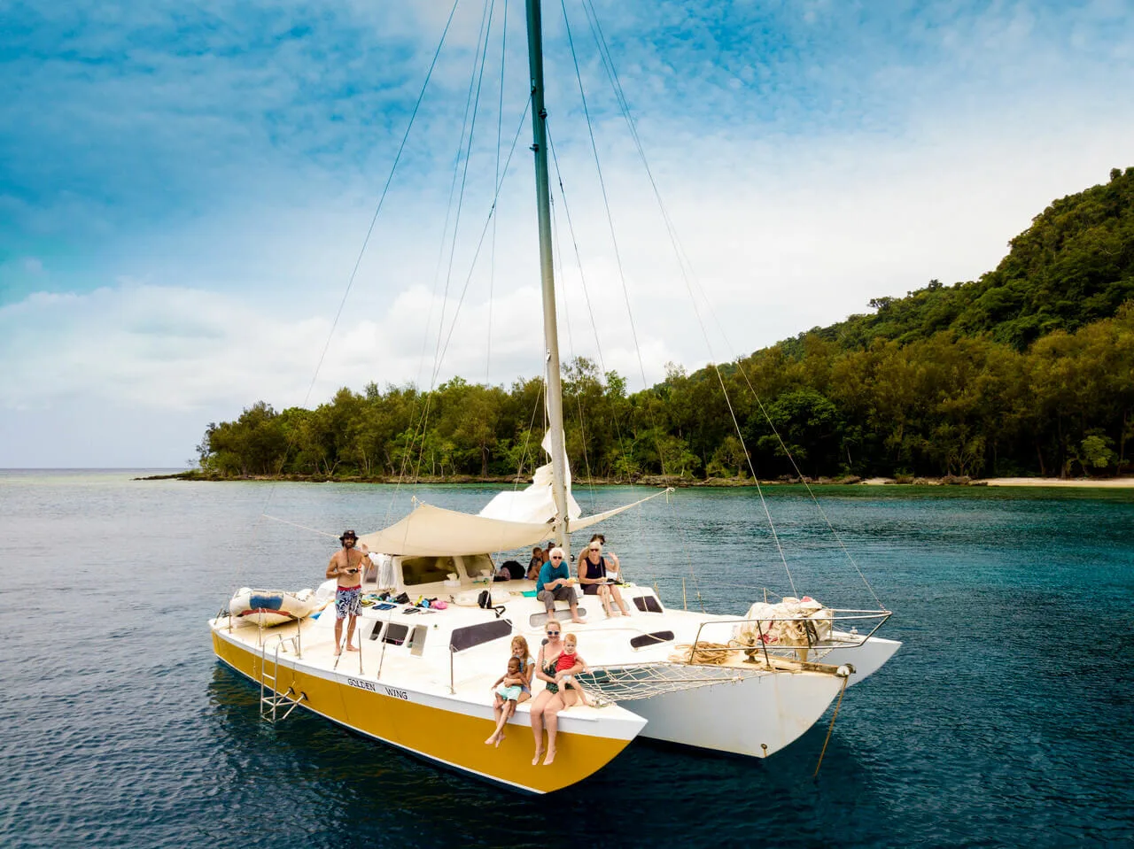 Family sitting on catamaran in the Vanuatu sea